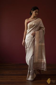 "With its rich floral web of zari, this regal\u00a0saree is truly representative of the royal clothing traditions of India. A luxurious piece of handwoven art!\n\n\n\nColor\u00a0- A\u00a0graceful shade of\u00a0Pastel Brown\n\nTechnique\u00a0- Classic handwoven Banarasi Zari Vasket art passed down through generations\n\nFabric\u00a0- Soft as butter, pure Katan Silk\n\nSpeciality\u00a0- A beautiful floral web of zari all over\u00a0the body and a rich border and pallu.\u00a0\n\nTilfi Promise\u00a0- Pure. Handloom. Banaras.\n\nNote\u00a0- The saree comes with its own blouse piece. The\u00a0model is wearing a separate blouse for styling purposes.\n\n\n\u00a0\nSince\u00a0this product is handwoven, there might be slight irregularities. But don't you think these add to the singular charm of a hand Luxury Katan Silk Blouse Piece With Border, Luxury Traditional Katan Silk Wear, Pastel Brown, Royal Clothing, Katan Silk, Handloom Saree, Fashion Drawing, Blouse Piece, One Shoulder Formal Dress