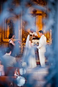 a bride and groom are getting married at the alter