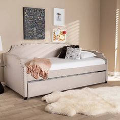 a day bed with trundle and pillows on it in a living room setting