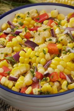 a bowl filled with corn and vegetables on top of a table