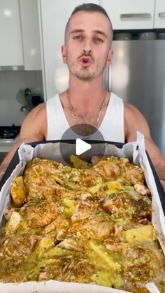 a man is holding up a large casserole dish