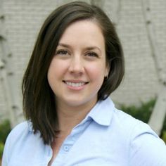 a woman in a blue shirt smiling at the camera