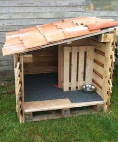 a dog house made out of wooden pallets