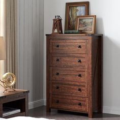 a wooden dresser sitting next to a window with pictures on the top and bottom shelf