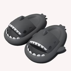 two gray slippers with teeth on the front and back of each shoe, one has an open mouth