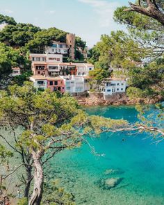 the water is crystal blue and clear with houses in the backgrounnds