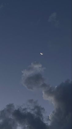 the moon is seen through some dark clouds