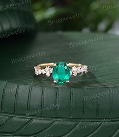 an emerald and diamond ring sitting on top of a tire