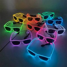 neon glasses are lined up on the floor, with one light turned on and two shades off