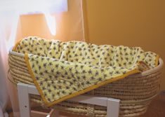 a baby's bassinet with a yellow and black bee print blanket on it