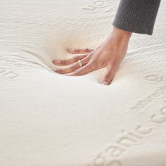 a person's hand on top of a mattress