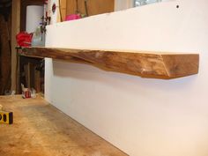 a piece of wood sitting on top of a wooden table next to a white wall