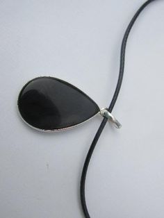 "This listing is for Adorable Black Onyx Necklace with Cord, 925 Silver Pendant. Total length is 4.2 cm or 1 1/2\". The stone is 2 x 3 cm. Perfect for any evening outfit; black dress, etc... You will love it:) Note: For all other jewelry: rings, earrings, necklaces visit my shop on www. bonanza. com Shop: edolena http://www.bonanza.com/booths/edolena \"Onyx Healing Properties Polished Onyx gemstone♥ Strength ♥ Stamina ♥ Constancy ♥ Permanence ♥ Firmness ♥ Durability ♥ Self-control Onyx is a vari Black Teardrop Necklace With Natural Stones, Black Enamel Round Pendant Jewelry, Black Jewelry With Large Pendant As Gift, Black Large Pendant Jewelry Gift, Black Teardrop Natural Stone Jewelry, Spiritual Black Jewelry With Large Pendant, Nickel Free Black Pendant Necklace, Black Round Pendant Jewelry With Natural Stones, Black Oval Natural Stone Necklaces