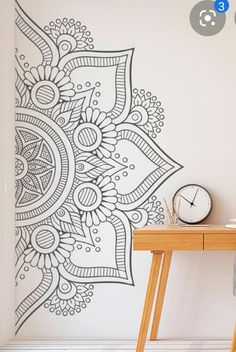 a table with a clock on top of it next to a wall decorated with an intricate design