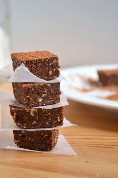 three pieces of brownie stacked on top of each other in front of a plate