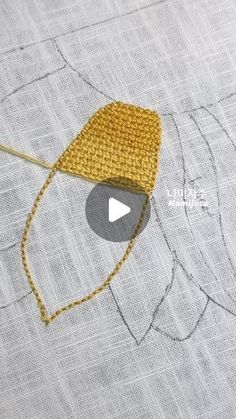 the video is showing how to sew an embroidered hat with yellow thread on it