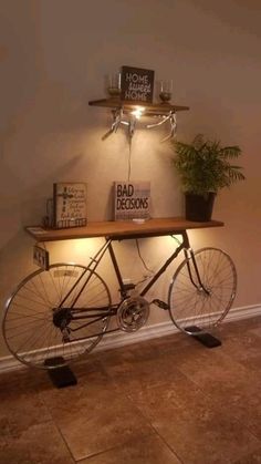 a bicycle is sitting under a shelf with some plants and books on top of it