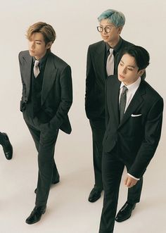 three men in suits and ties standing next to each other with their hands on their hipss