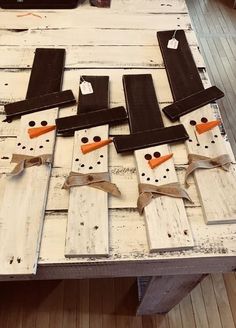 snowmen made out of wooden planks sitting on top of a table