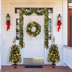 the front door is decorated with christmas wreaths and lights