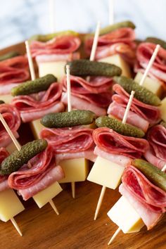 many different types of food on sticks with cheese and pickles attached to them,