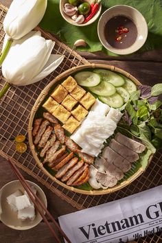 a bowl filled with meat and vegetables on top of a table next to chopsticks