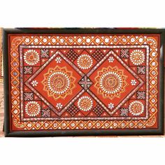 an orange and black tray with designs on it