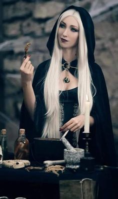 a woman with long white hair holding a candle