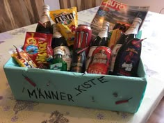 a blue box filled with lots of different types of drinks and snacks on top of a table