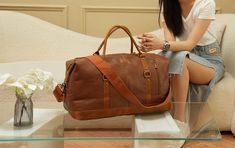 Discover unparalleled elegance with the FR Fashion Co. Leather Travel Duffel Bag. Crafted from premium vegan leather, this duffel is your ultimate companion for short trips, offering both unmatched style and substantial space. Its vintage brown accents and red lining enhance its aesthetic appeal, making it a sophisticated choice for any traveler. Key Features: Material: High-quality vegan leather with vintage brown accents and red lining for a classic look. Spacious Capacity: Dimensions of 20x15x9 inches provide ample space for all your essentials, ideal for weekend or 4-5 day trips. Versatility: Perfect as a carry-on, gym, sport, or overnight travel bag, meeting most airline requirements. Functional Design: Features a detachable & adjustable shoulder strap made of heavy-duty canvas and du Elegant Brown Weekender Bag For On-the-go, Elegant Brown Duffle Bag For On-the-go, Elegant Brown Duffle Bag With Large Capacity, Elegant Large Capacity Brown Travel Bag, Elegant Brown Weekender Bag With Leather Trim, Elegant Brown Satchel Duffle Bag, Elegant Brown Everyday Duffle Bag, Chic Brown Duffle Bag For Daily Use, Elegant Large Capacity Brown Weekender Bag