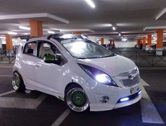 a small white car parked in a parking garage