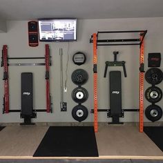 a gym room with various equipment and a flat screen tv mounted on the wall above it