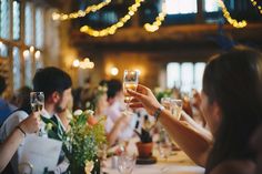 people sitting at a table with wine glasses in their hands