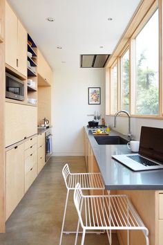 a laptop computer sitting on top of a kitchen counter