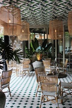 an outdoor restaurant with wicker chairs and plants