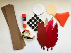 paper, scissors, and other crafting supplies laid out on a white table top