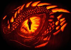 a carved pumpkin with an image of a dragon's eye in the middle of it