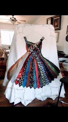 a dress made out of old ties sitting on top of a chair in a room