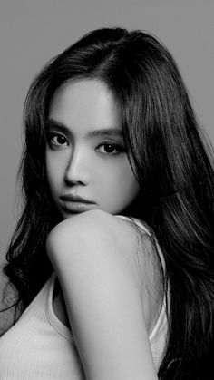 a black and white photo of a woman with long dark hair wearing a tank top