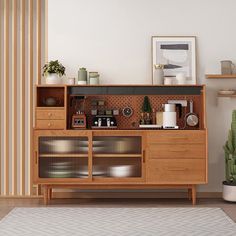 a wooden cabinet with many items on it in a living room next to a cactus