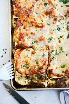 lasagna casserole with meat, cheese and parsley on the side