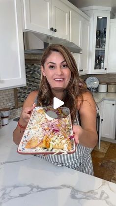 a woman holding a plate with food on it