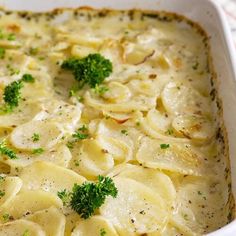 a casserole dish with pasta and broccoli garnished with parsley