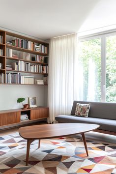 a living room with bookshelves and a couch in front of a large window