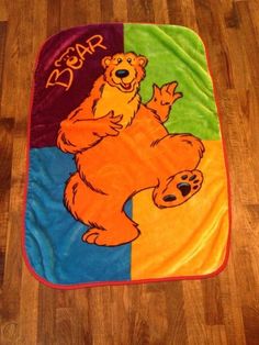 a colorful bear blanket sitting on top of a wooden floor