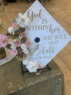 a graduation cap decorated with flowers and the words god is within her she will not fall