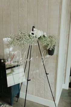 an easel with flowers and baby's breath on it