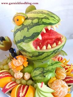 there is a watermelon sculpture made to look like a frog with his mouth open