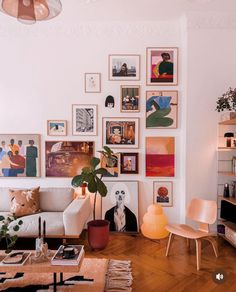 a living room filled with furniture and lots of pictures on the wall above it's coffee table