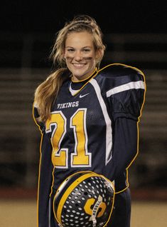 a woman holding a soccer ball and glove